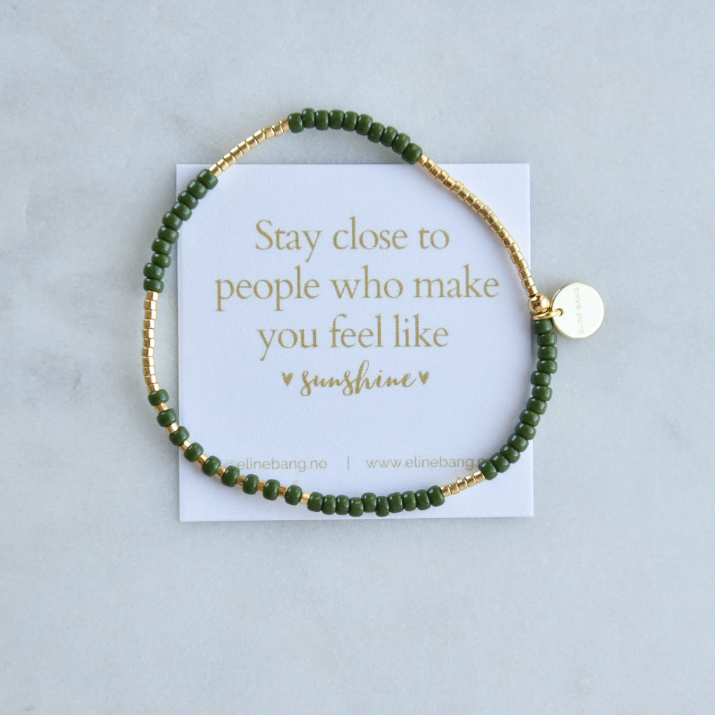 Elastisk armbånd med grønne glassperler og gullbelagte detaljer